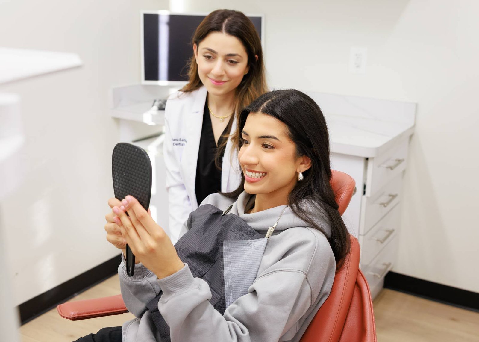 A Naeem Family Dentistry patient admiring her new smile after cosmetic treatment